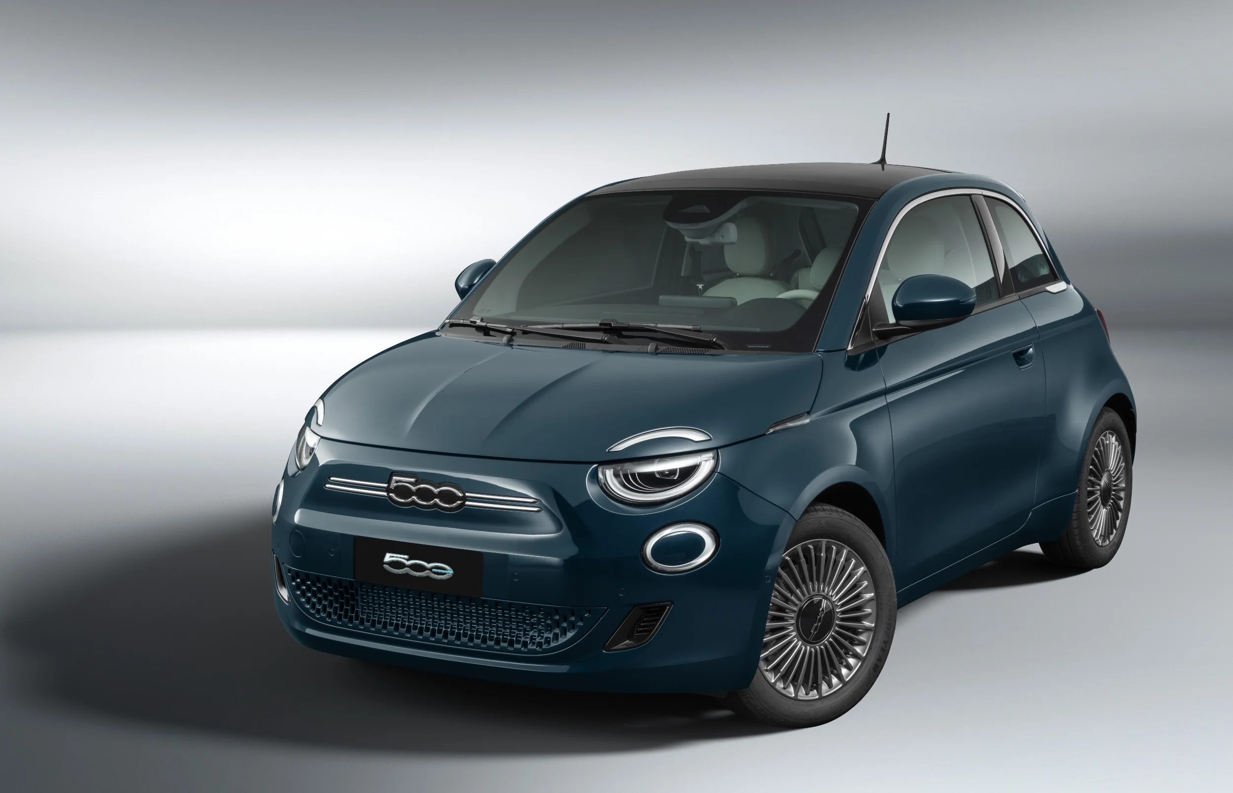 Vista frontal do Fiat 500e na cor verde oceano, em fundo claro.