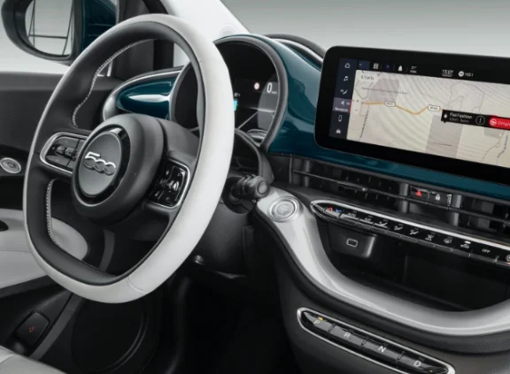 Vista do interior do Fiat 500e com ênfase no painel do carro, com detalhes em branco, azul e prata.