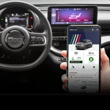 Cabine do Novo Fiat 500e, com motorista segurando smartphone conectando aos serviços conectados Fiat, com informações do veículo na tela do celular.