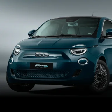 Vista frontal do Fiat 500e na cor verde oceano, com fundo claro.